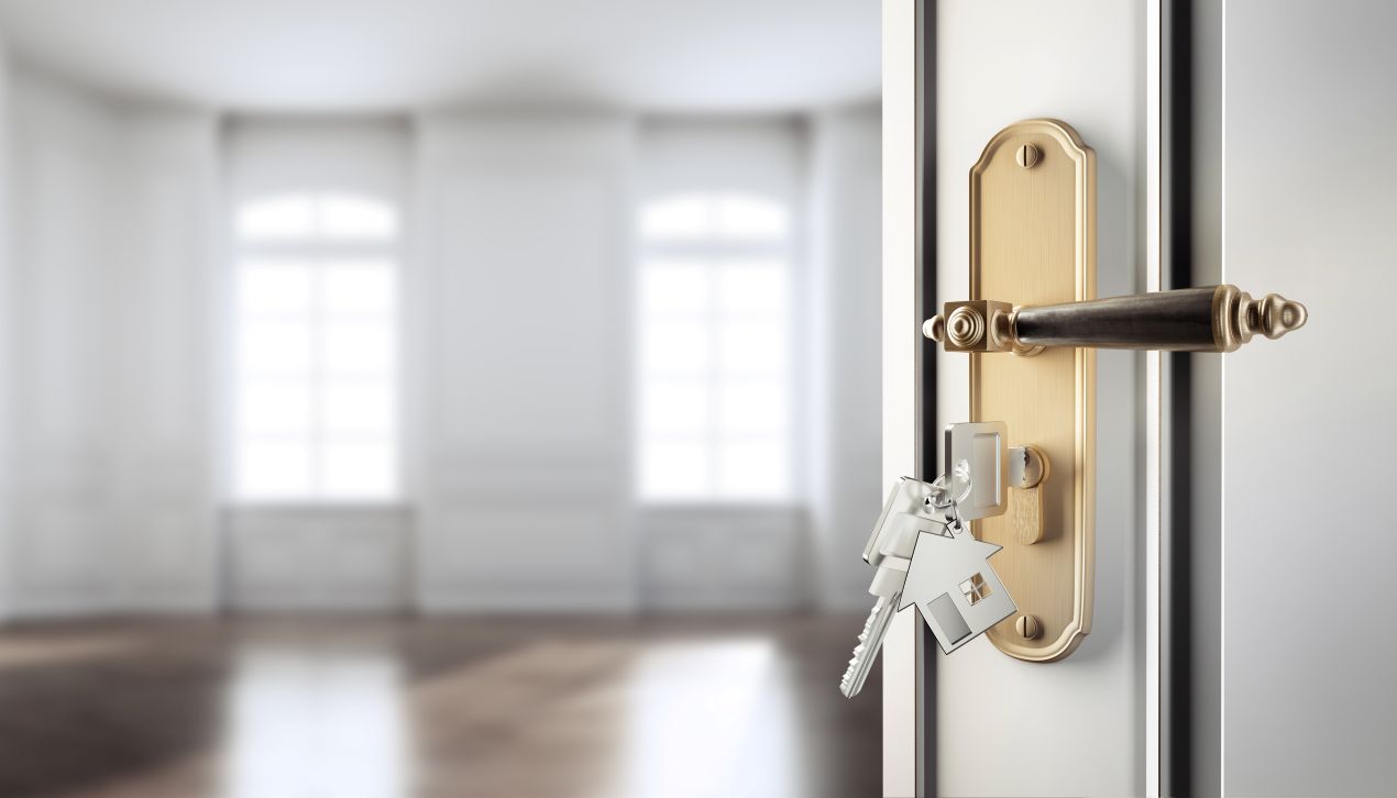Offene Tuer mit Schluesselbund und leerer renovierter Raum – Symbol fuer wohnungssanierung berlin